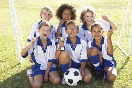 Group Of Children In Soccer Team Celebrating With Trophyの写真素材