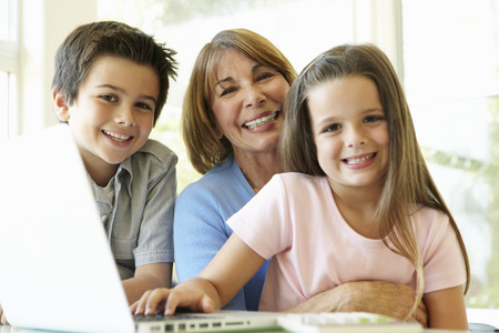 Hispanic Grandmother Using Laptop With Grandchildren
