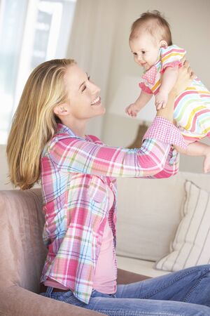 Young Mother On Sofa At Homeの写真素材