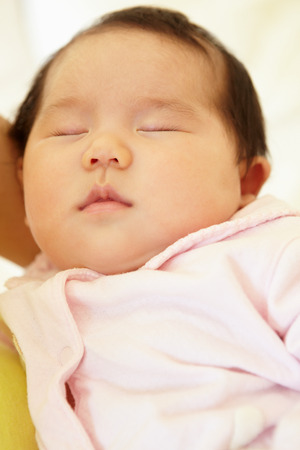 Vietnamese mother cuddling babyの写真素材