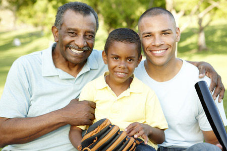 African American Grandfather, Father And Son Playing Baseball In Park