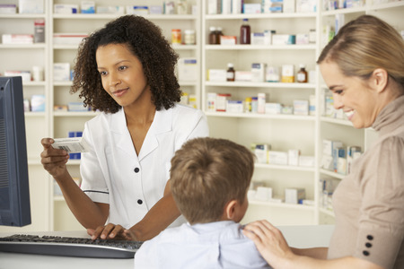 Pharmacist in pharmacy with mother and childの写真素材