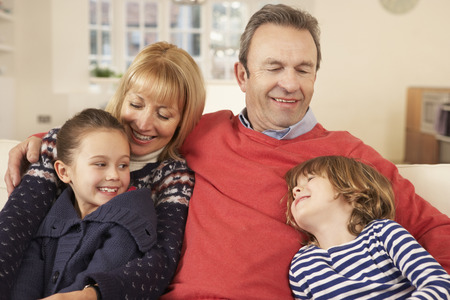 Portrait grandparents and grandchildren at homeの写真素材