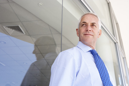 Mature Businessman Standing Outside Modern Officeの写真素材