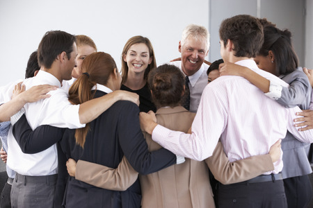 Group Of Businesspeople Bonding In Circle At Company Seminar