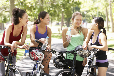 Group Of Women Resting During Cycle Ride Through Parkの写真素材