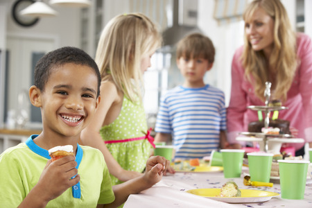 Group Of Children Enjoying Birthday Party Food At Tableの写真素材