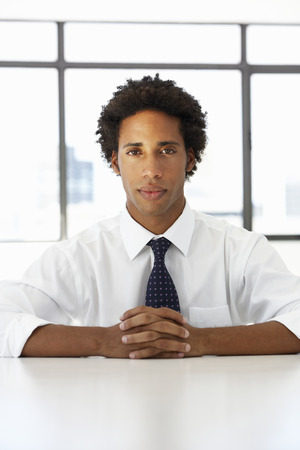 Businessman Sitting At Desk In Office Thinkingの写真素材