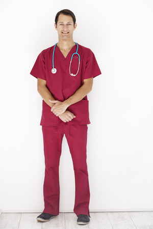 Studio Portrait Of Doctor Leaning Against White Backgroundの写真素材