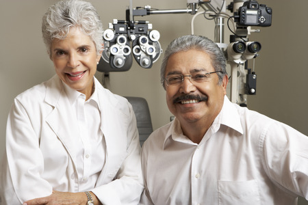 Portrait Of Female Optician With Patient In Surgeryの写真素材