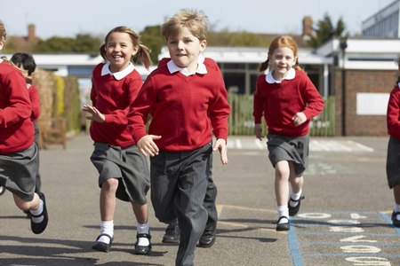 Elementary School Pupils Running In Playgroundの写真素材