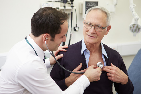 Doctor Examining Senior Male Patient In Hospitalの写真素材