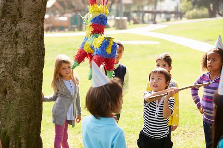 Children Hitting Pinata At Birthday Partyの写真素材
