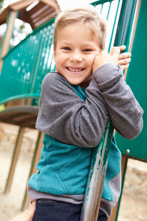 Young Boy On Climbing Frame In Playgroundの写真素材
