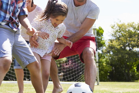 Family Playing Football In Garden Togetherの写真素材