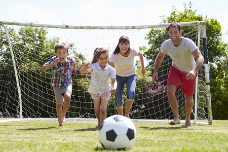 Family Playing Football In Garden Togetherの写真素材