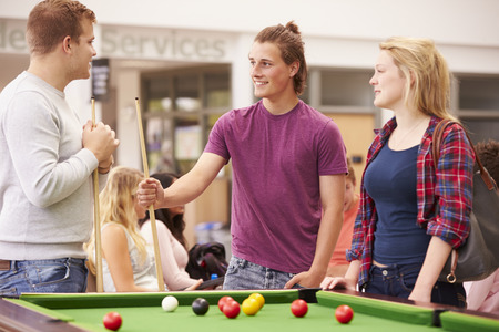 College Students Relaxing And Playing Pool Together