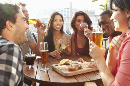 Group Of Friends Enjoying Drink And Snack In Rooftop Barの写真素材