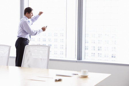 Businessman On Mobile Phone In Boardroomの写真素材