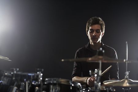Young Drummer Playing Drum Kit In Studioの写真素材