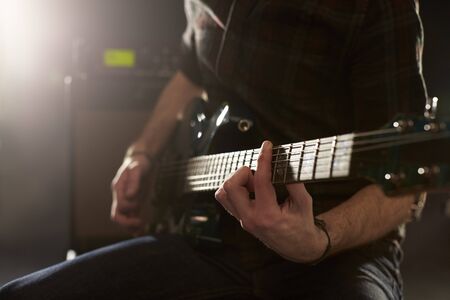 Close Up Of Man Playing Electric Guitar In Studioの写真素材