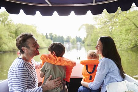 Family Enjoying Day Out In Boat On River Togetherの写真素材