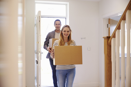 Couple Carrying Boxes Into New Home On Moving Dayの写真素材