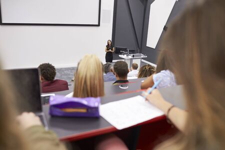 Woman lecturing students in a lecture theatre, student POVの写真素材