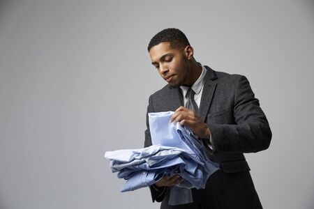 Studio Portrait Of Male Fashion Buyer Looking At Shirtsの写真素材