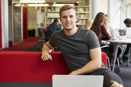 Portrait Of Male University Student Working In Library