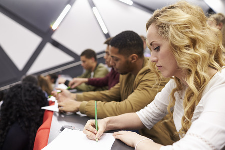 Female student taking notes in a university lecture theatreの写真素材