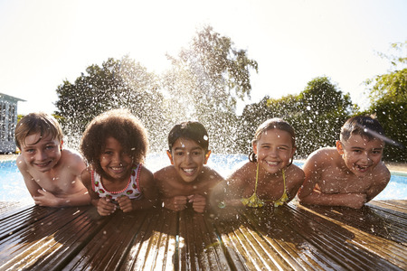 Portrait Of Children Having Fun In Outdoor Swimming Poolの写真素材