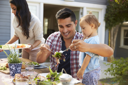 Family At Home Eating Outdoor Meal In Garden Togetherの写真素材