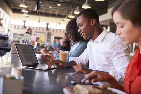 Business People Working At Counter In Coffee Shopの写真素材
