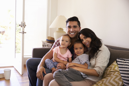 Portrait Of Happy Family Sitting On Sofa In at Homeの写真素材