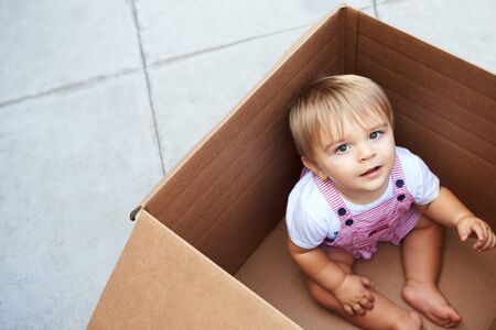 Little Boy Playing Inside Moving In Boxの写真素材