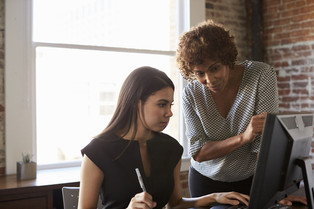 Two Businesswomen Working On Computer In Officeの写真素材