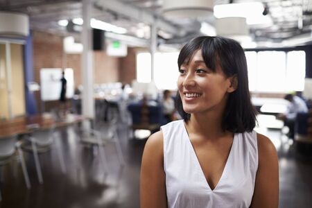 Businesswoman Standing In Modern Open Plan Office