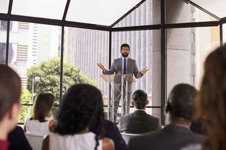 Hispanic man gesturing to audience at business seminarの写真素材
