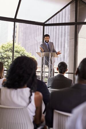 Hispanic man presents business seminar to audience, verticalの写真素材