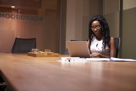 Young black businesswoman working late on laptop in officeの写真素材