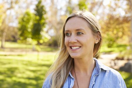 Mid thirties white woman looking away from camera in park