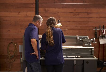 Rear View Of Engineer Training Apprentice On Milling Machineの写真素材