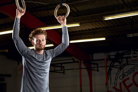 Portrait Of Young Man In Gym With  Rings