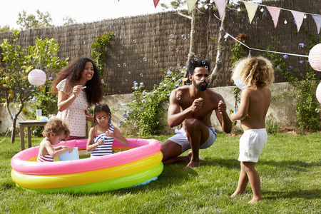 Family Having Fun In Garden Paddling Poolの写真素材