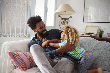 Father And Son Playing Game On Sofa Togetherの写真素材