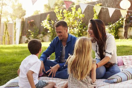 Family Relaxing On Blanket In Gardenの写真素材
