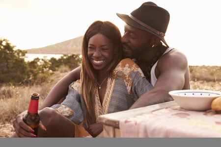 Couple Enjoying Picnic On Cliffs By Seaの写真素材