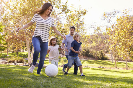 Family Playing Soccer In Park Togetherの写真素材