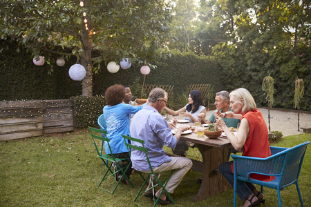 Group Of Mature Friends Enjoying Outdoor Meal In Backyardの写真素材